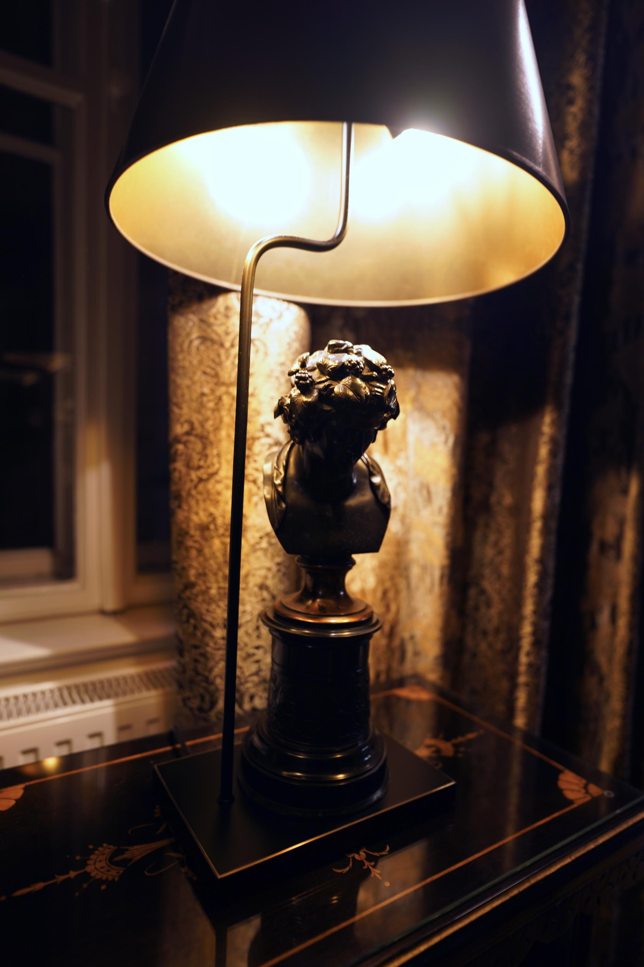 Gäste im Gespräch bei warmem Licht im Salon.